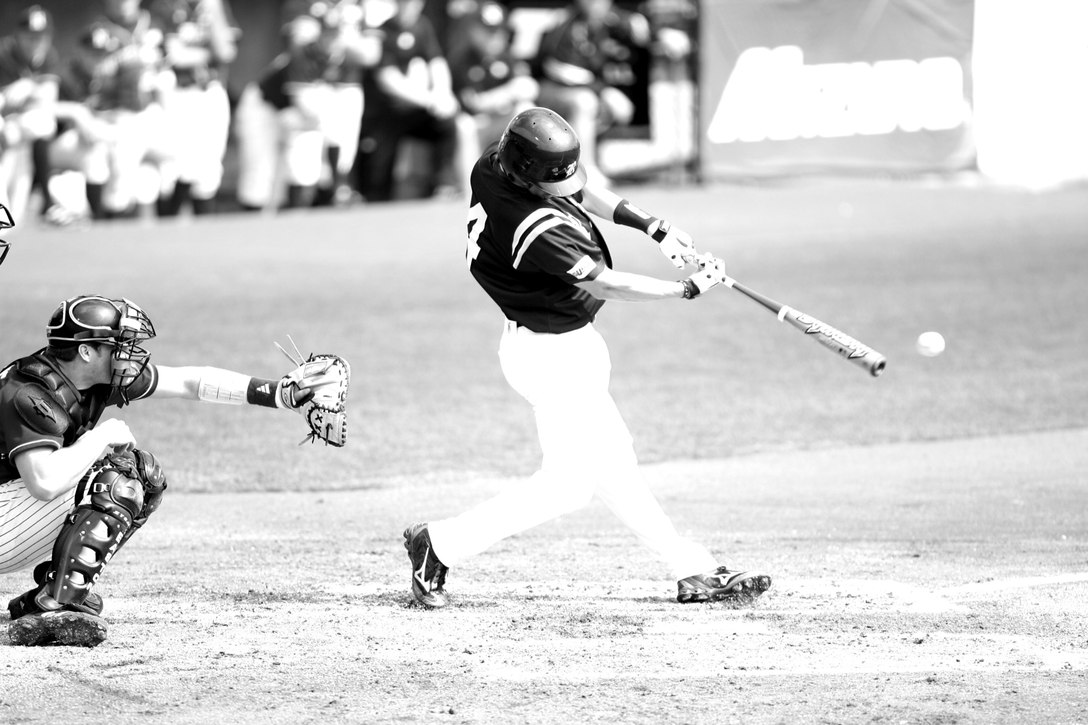A college baseball player making contact at the plate
